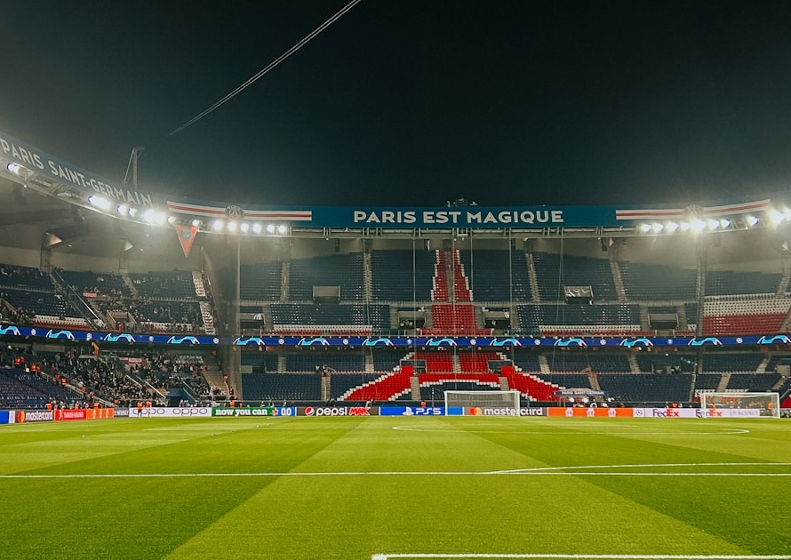 Pelouse du Parc des Princes à Paris illuminée la nuit, symbole de la mobilité des sportifs professionnels vers la France