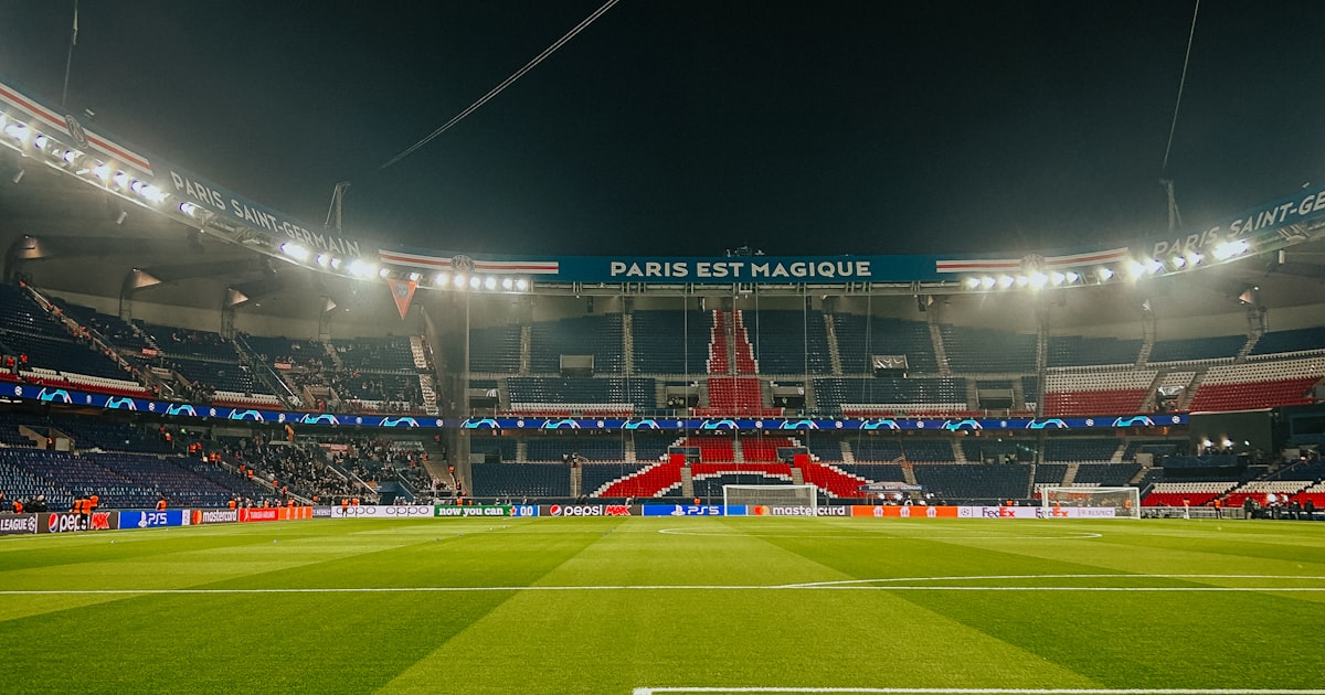 Pelouse du Parc des Princes à Paris illuminée la nuit, symbole de la mobilité des sportifs professionnels vers la France